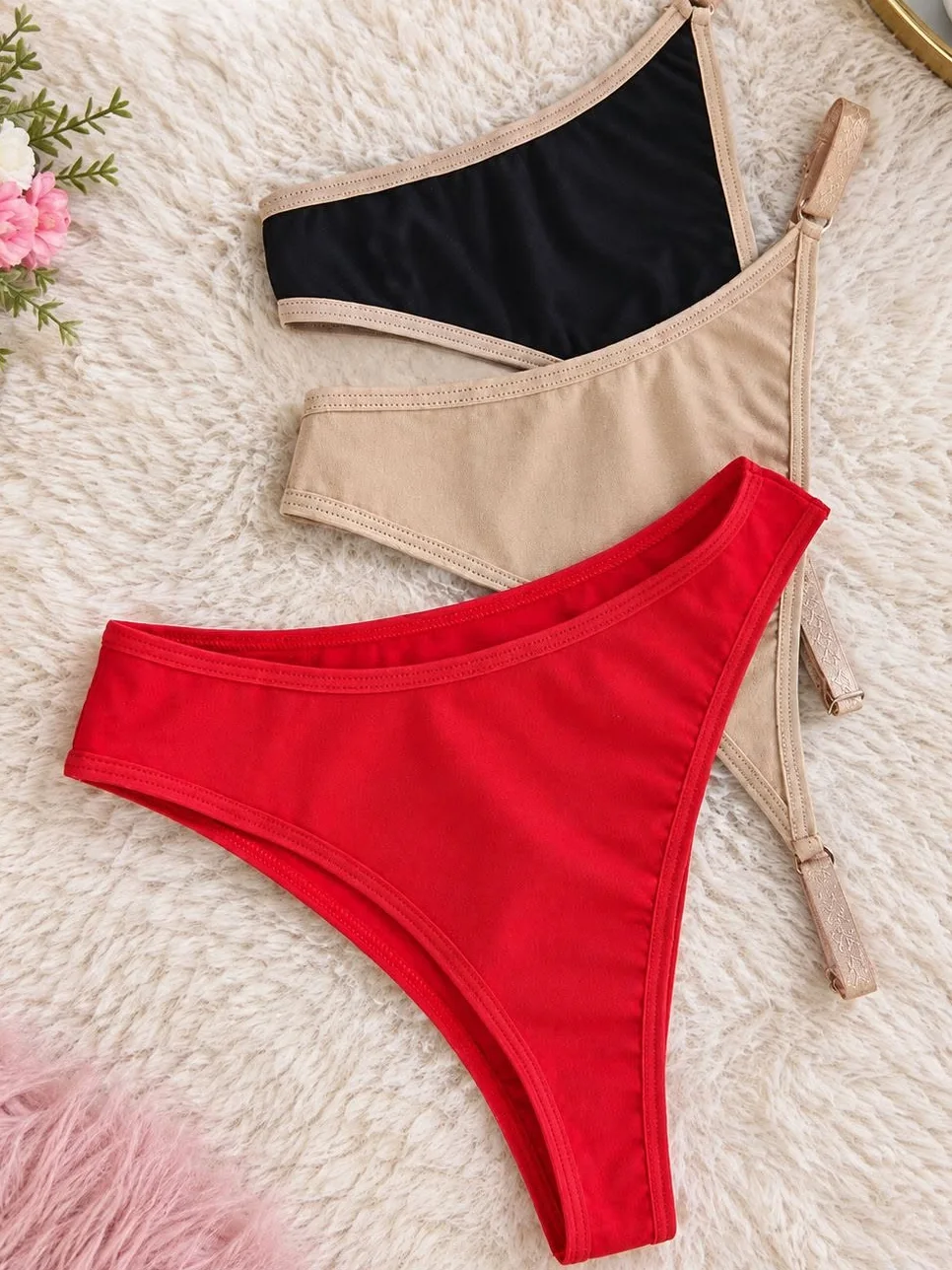 Tres prendas íntimas Mitsuri —negro, nude y rojo— sobre una alfombra clara, con flores a un costado